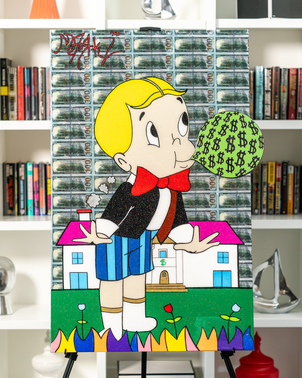 Blowing Money by Chris Marchese on an easel in front of a bookcase
